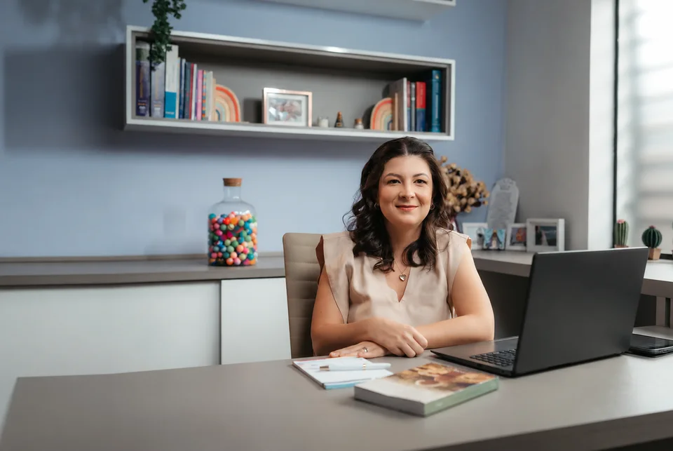 Dra. Ana Carolina Lopes Held sentada à mesa em seu consultório em Bauru